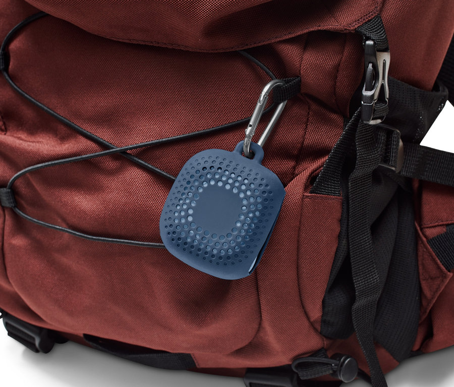 Ein blaues Outdoor-Handtuch ist mit einem Karabiner an einem braunen Rucksack befestigt.