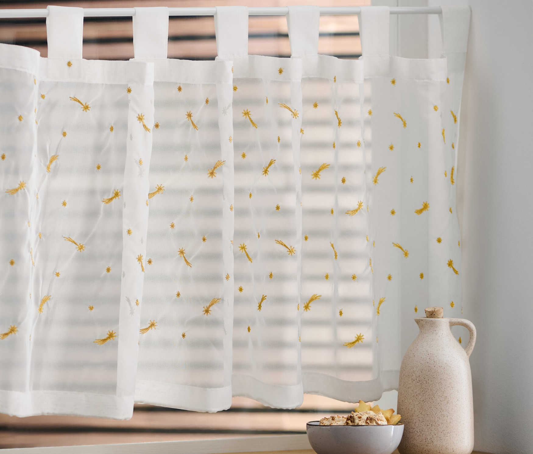 Bestickte Bistro-Gardine am Fenster.