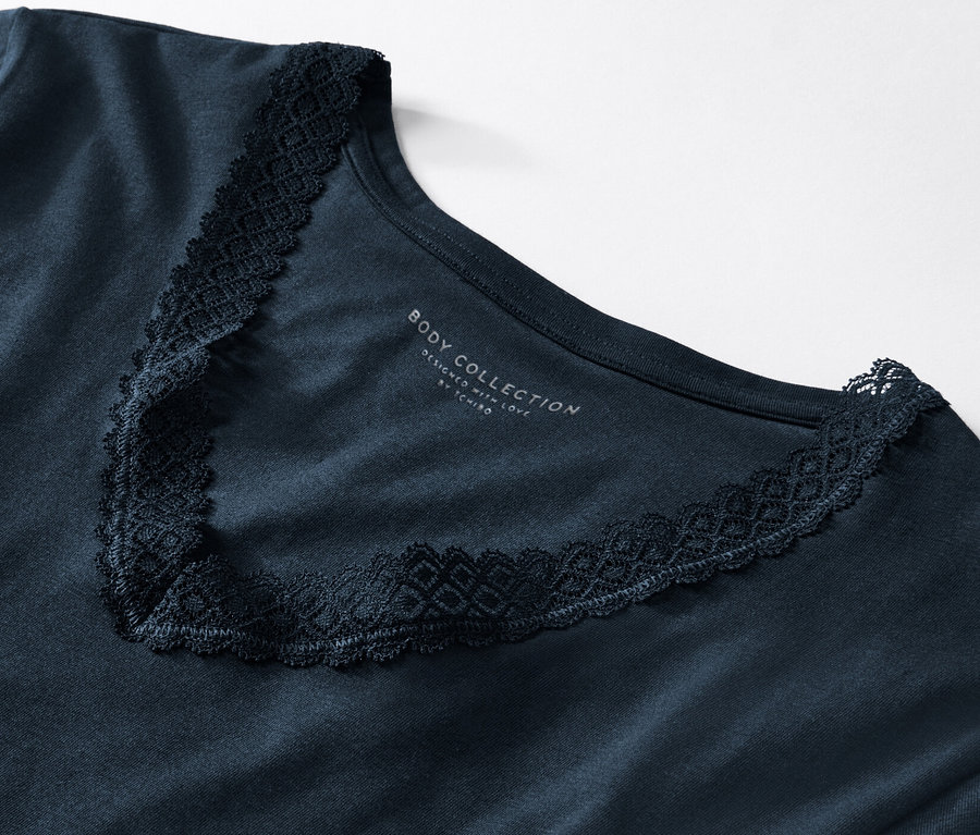 Detailansicht eines blauen Langarm-Unterhemds mit Spitzenbesatz.