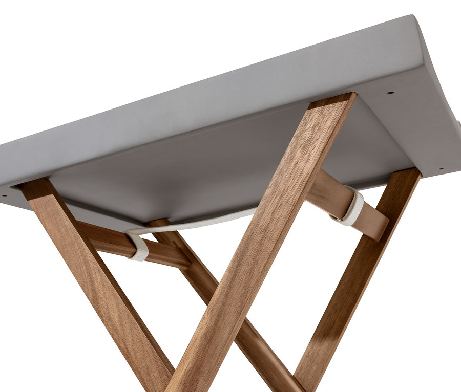 Detailaufnahme eines grauen Tisches mit Polyzementplatte und Holzbeinen von unten.