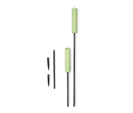 Zwei LED-Gartenfackeln mit grünem Gehäuse und schwarzem Stab liegen auf weißem Hintergrund.