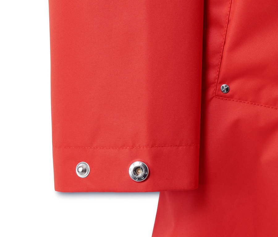 Detailansicht einer roten 3-in-1-Regenjacke mit silbernen Druckknöpfen.