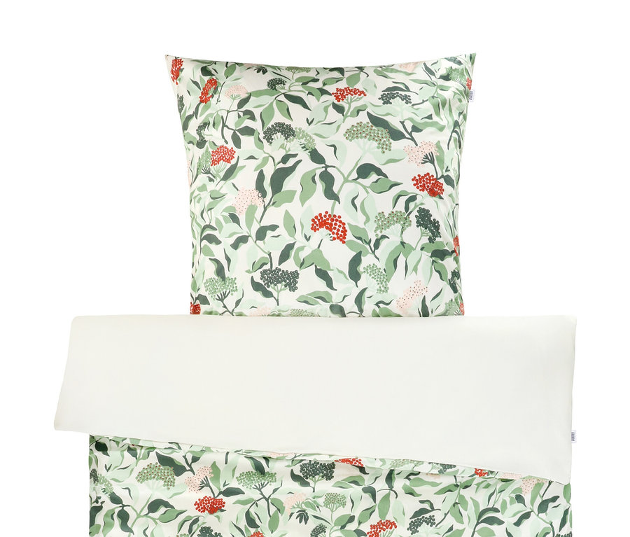 Weiße Bettwäsche mit Blatt- und Beerenmuster.