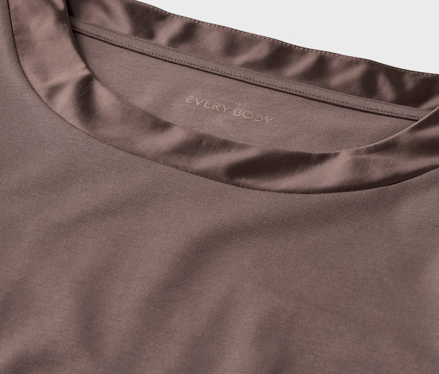 Detailansicht eines braunen T-Shirts mit Einfassung und dem Schriftzug EVERY BODY.