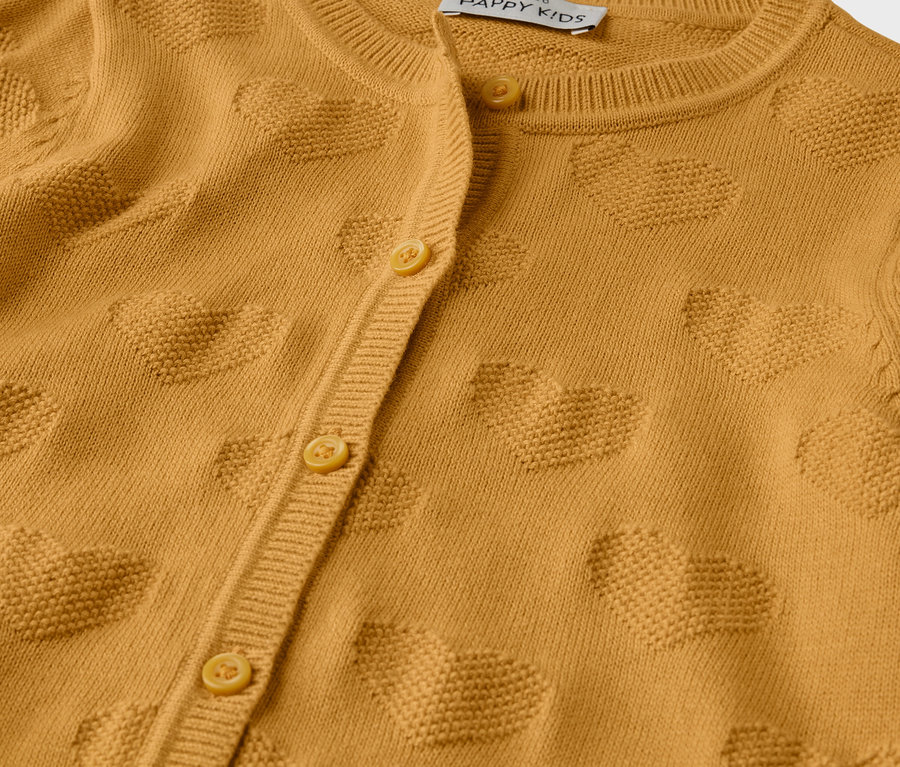Detailansicht einer Kinder-Strickjacke in Senfgelb mit Knopfleiste und Herzmuster.