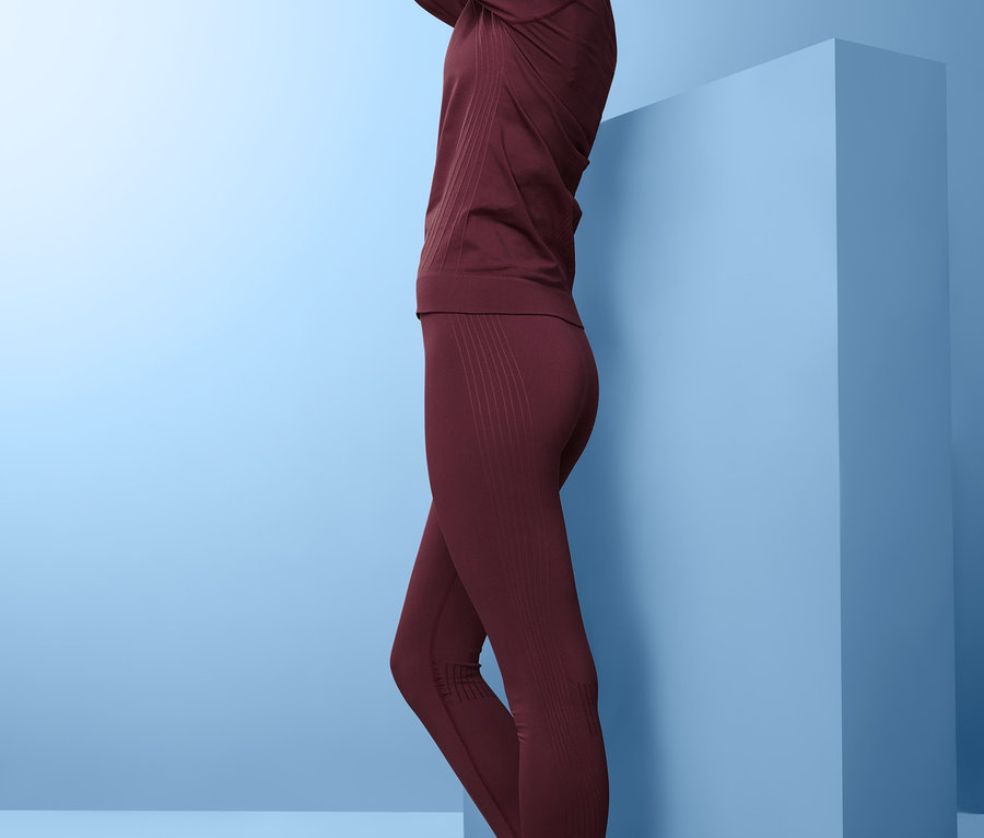 Frau posiert in nahtloser Funktionsunterwäsche in Burgunderrot.