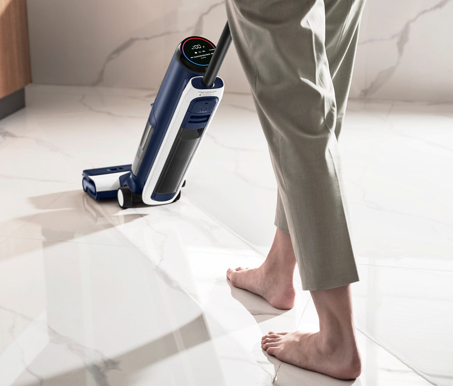 Eine Person benutzt einen Tineco Nass-Trockensauger S6 Flashdry PET auf einem nassen Boden.