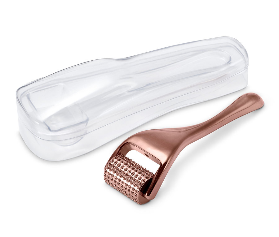 Ein Gesichtsroller und seine transparente Hülle liegen auf einem weißen Hintergrund.