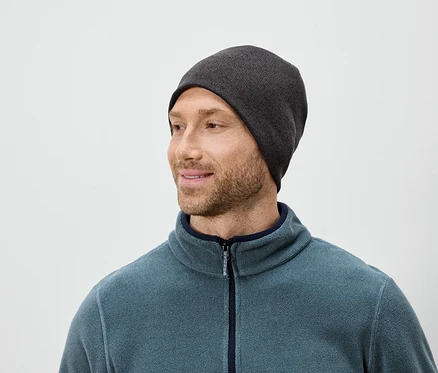 Mann mit Bart, grauer Mütze und blauem Fleecepullover blickt nach rechts.