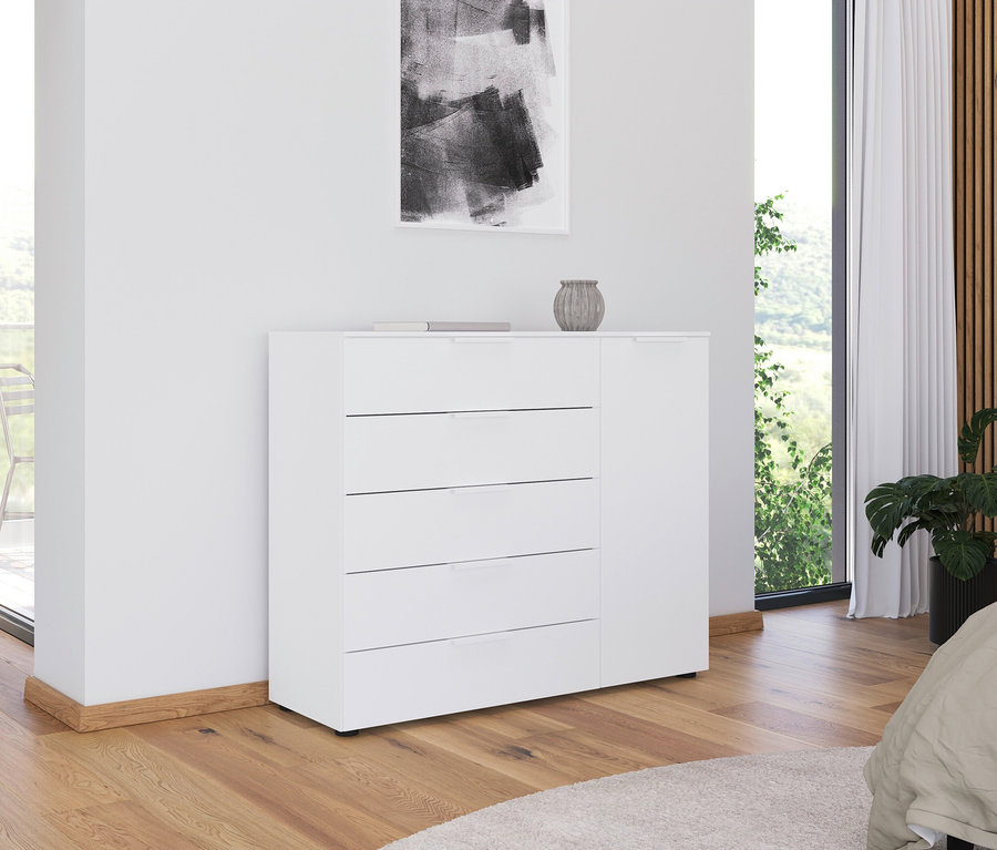 Weiße Kommode mit vier Schubladen und einem Schrank steht an einer Wand im Zimmer.