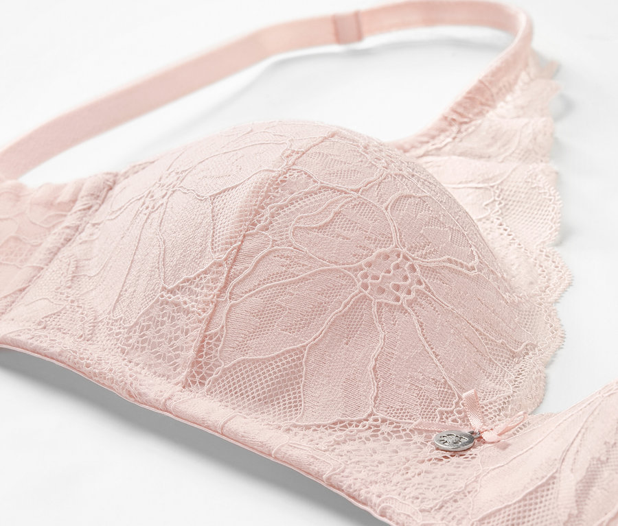 Detailaufnahme eines roséfarbenen Softschalen-BHs mit Spitze.