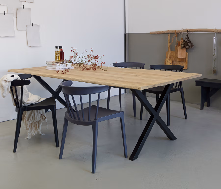 Holzesstisch mit schwarzem Metallgestell, umgeben von vier Stühlen in verschiedenen Grautönen.