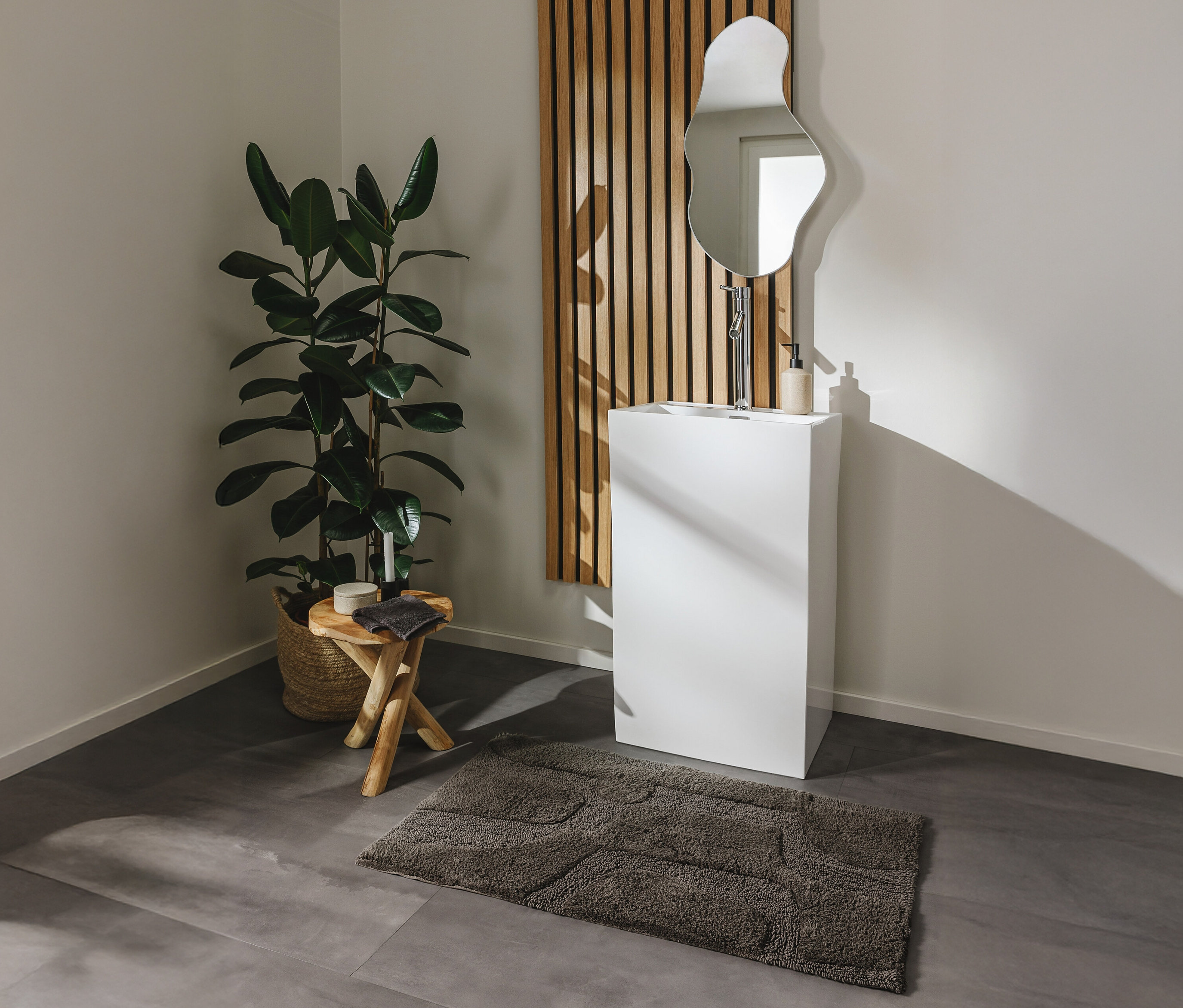 Ein Badezimmer mit einem Waschbecken, einem Spiegel und einer grauen Badematte »Nehir« von benuta in verschiedenen Größen.