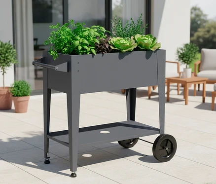 Grauer rollbarer Pflanztisch mit Kräutern und Salatpflanzen auf einer Terrasse.