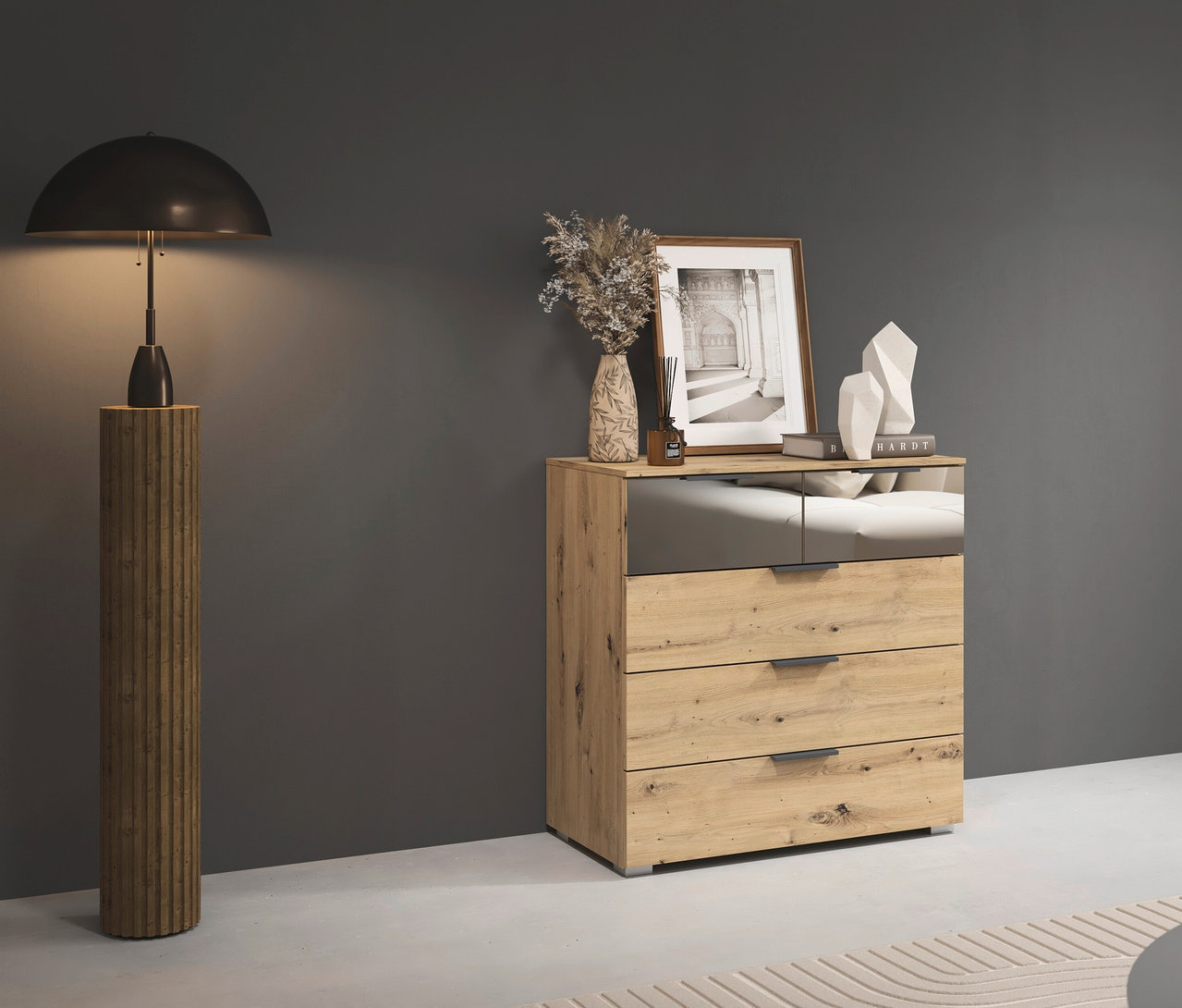 Eine rauch Kommode »Skyla« mit 5 Schubladen in Eiche steht neben einer Stehlampe.