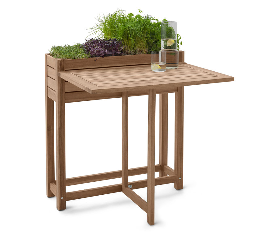 Hölzerner Pflanztisch mit Kräutern und zwei Gläsern Wasser.