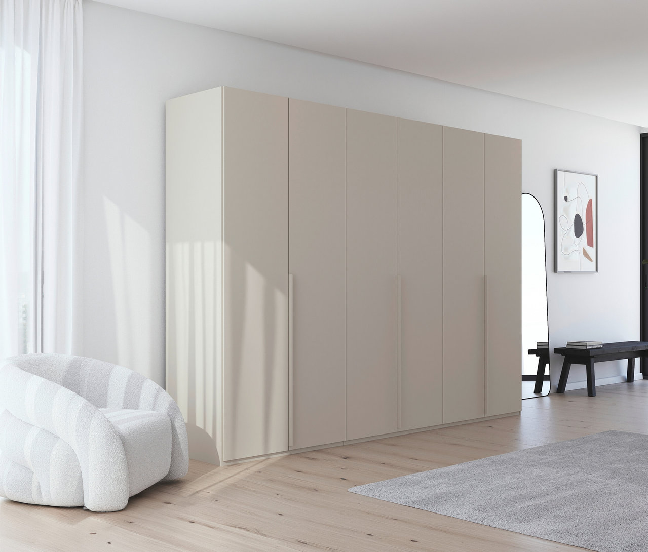 Innenraum mit großem, beigefarbenem Kleiderschrank, weißem Sessel, Spiegel und Bank. Ein grauer Teppich liegt auf dem Holzboden.
