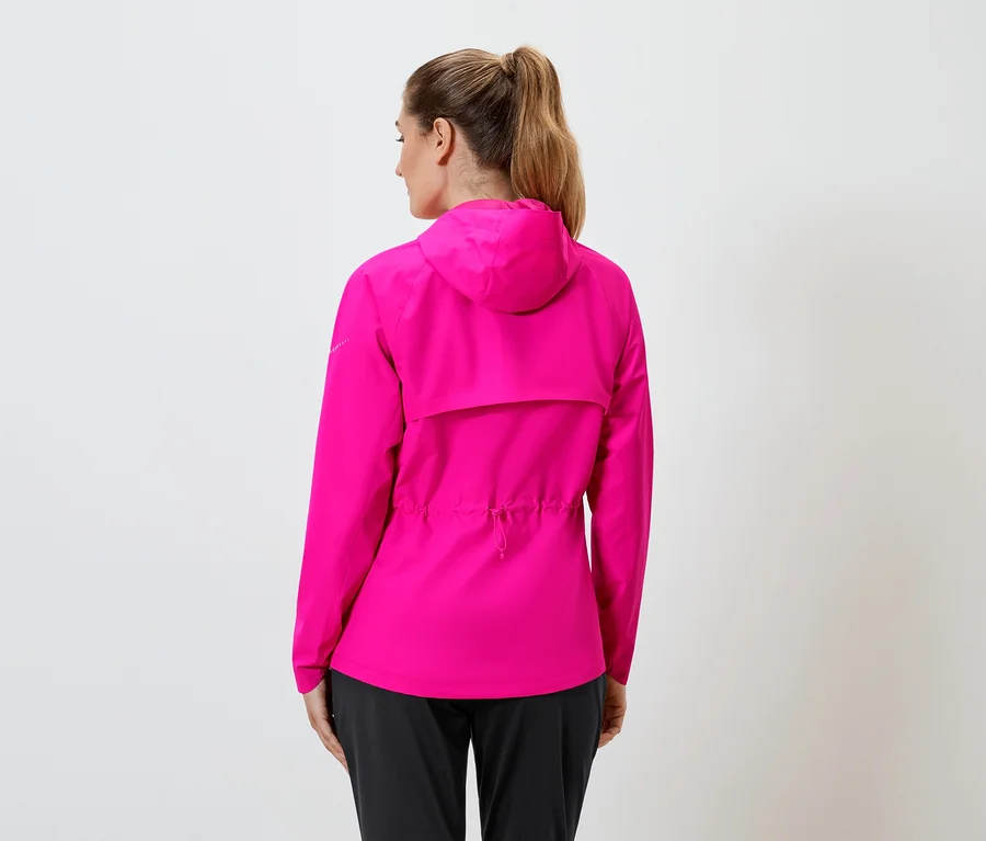 Rückansicht einer Frau mit Pferdeschwanz in einer pinkfarbenen Regenjacke mit Kapuze und schwarzen Hosen vor einem weißen Hintergrund.