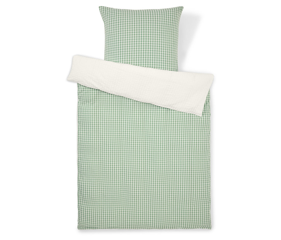 Bettwäsche-Set mit grün-weiß kariertem Muster und weißem Kissenbezug, von oben fotografiert.