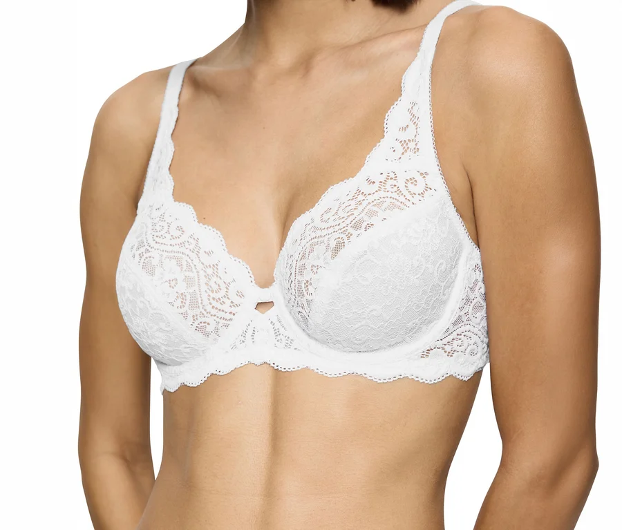 Frau trägt einen weißen Triumph Amourette W BH aus Spitze mit gewelltem Rand und floralem Muster, mit einer kleinen Schleife zwischen den Cups.