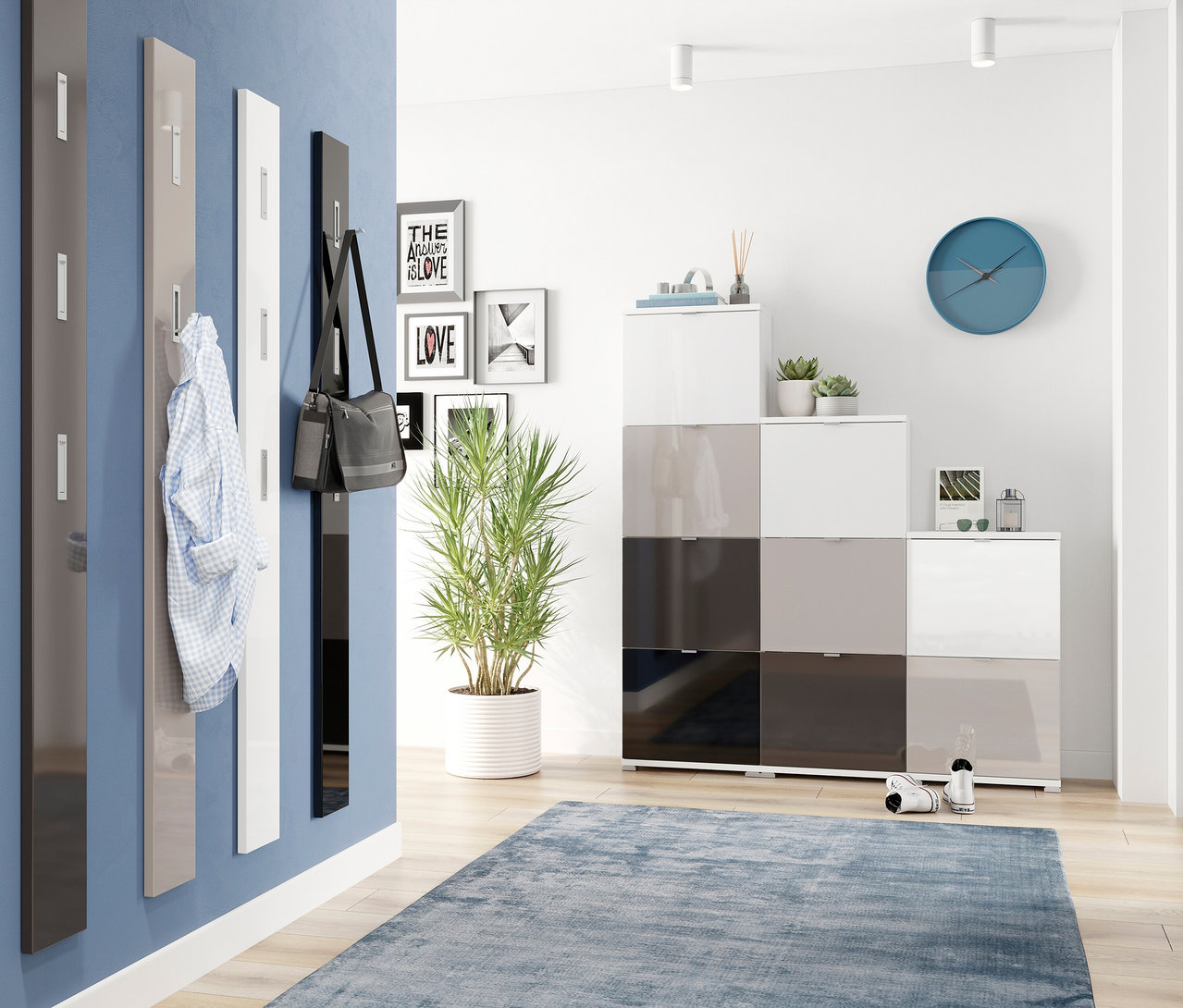 Vier Garderobenpaneele an blauer Wand: dunkelgrau, hellgrau mit Hemd, weiß und ein schwarzes Garderobenpaneel mit silberfarbenen Haken und Tasche. Modulare Aufbewahrung, Pflanze, blauer Teppich.