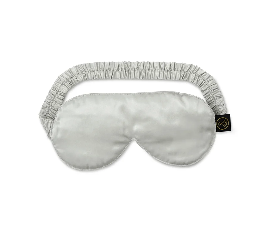 Eine silberne Seiden-Schlafmaske mit einem elastischen Zugband.
