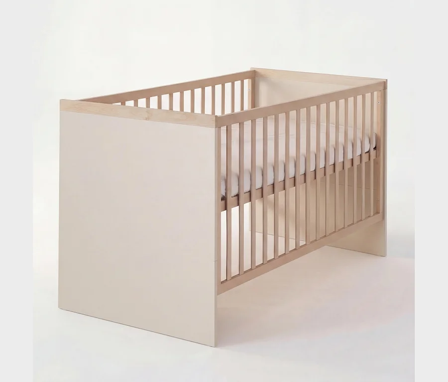 Ein hellbeiges und naturfarbenes Babybett mit Gitterseiten und massiven Endteilen, das eine weiße Matratze enthält.