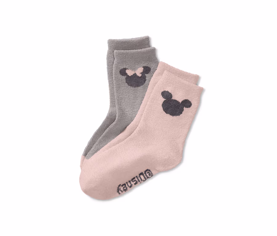 Zwei Paar flauschige Disney Socken: ein Paar rosa mit Mickey Mouse Motiv, ein Paar grau mit Minnie Mouse Motiv.