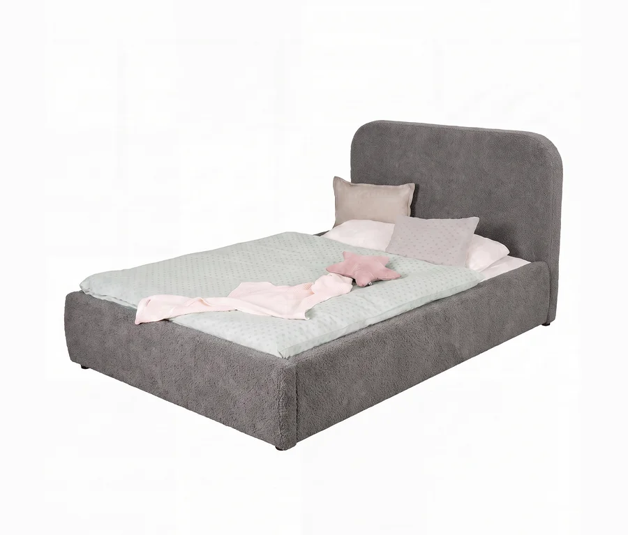 Ein Einzelbett mit einem dunkelgrauen, strukturierten Polsterrahmen und geschwungenem Kopfteil. Es hat hellgrüne gepunktete Bettwäsche, eine gefaltete rosa Decke und drei Kissen: weiß, beige und ein rosa Sternkissen.