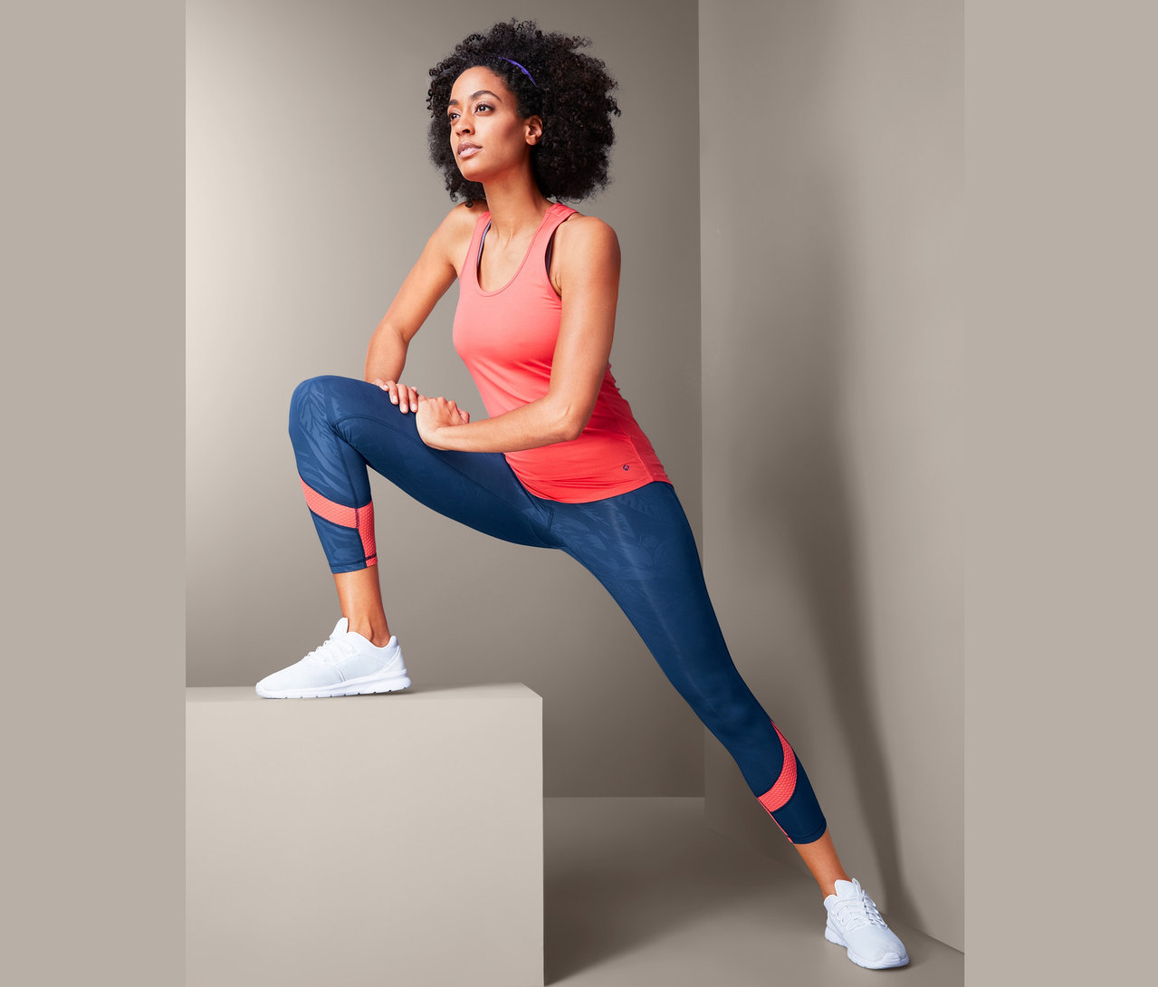 Eine Frau dehnt sich in einer 7/8-Sporttight.