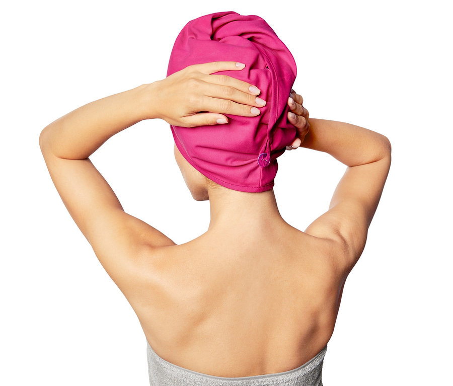 Frau setzt Turban-Sporthandtuch auf.