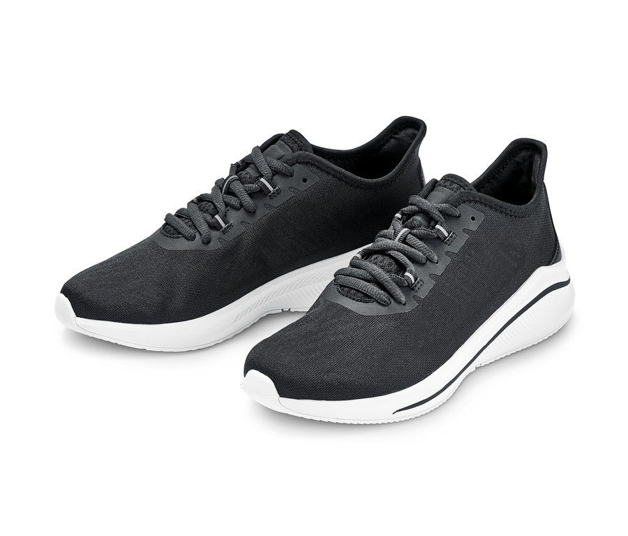 Zwei schwarze Sneaker mit weißen Sohlen.
