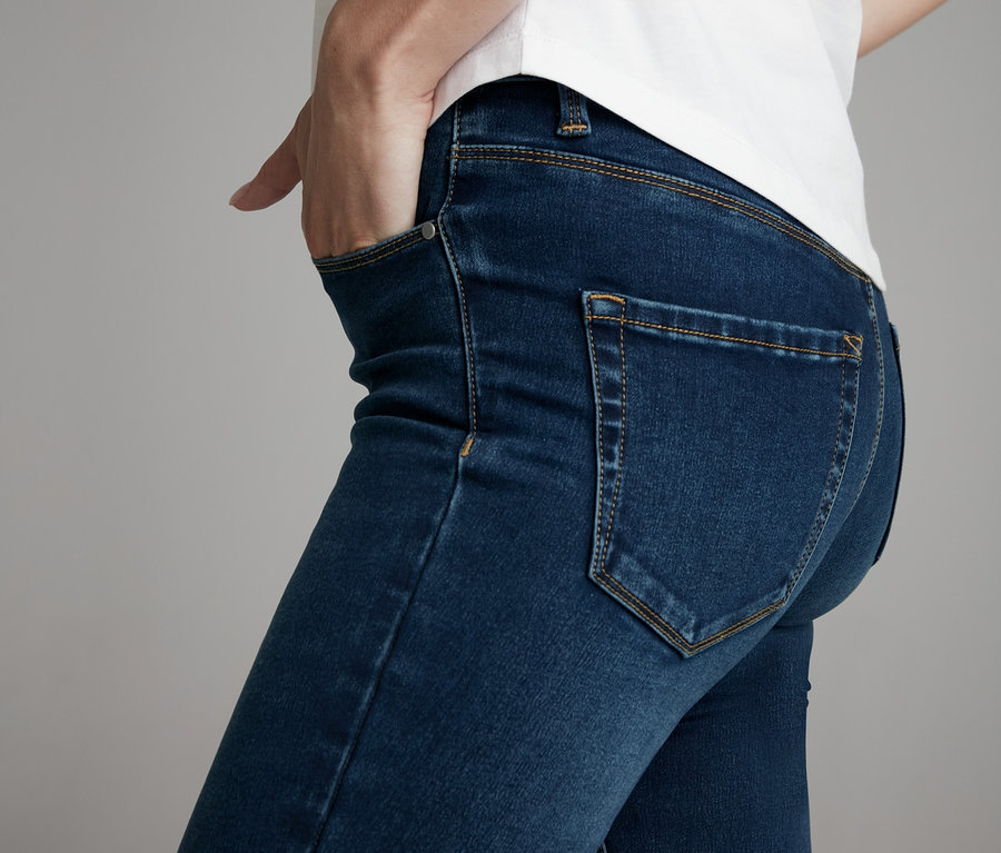 Frau trägt eine Skinny-Jeans und ein weißes T-Shirt.