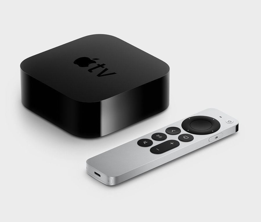 Ein schwarzer Apple TV 4K 2021, 32GB und eine silberne Fernbedienung auf hellgrauem Hintergrund.