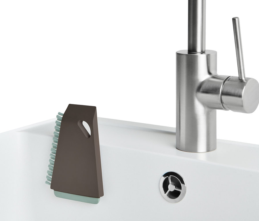 Eine Universal-Küchenbürste steht neben einem Edelstahl-Wasserhahn in einem weißen Waschbecken.