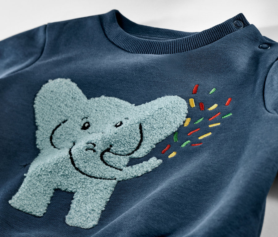 Detailaufnahme eines blauen Kinder-Sweatshirts mit angerauter Innenseite und Elefantenapplikation.