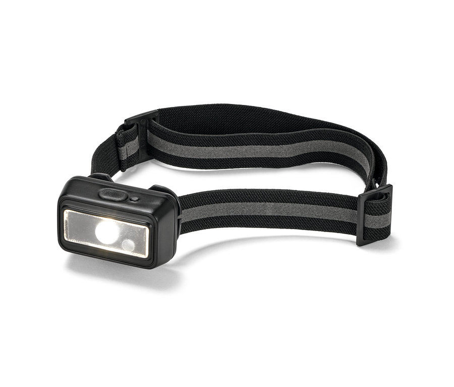 Nahaufnahme einer kompakten Stirnlampe mit schwarzem Band und eingeschaltetem Licht.