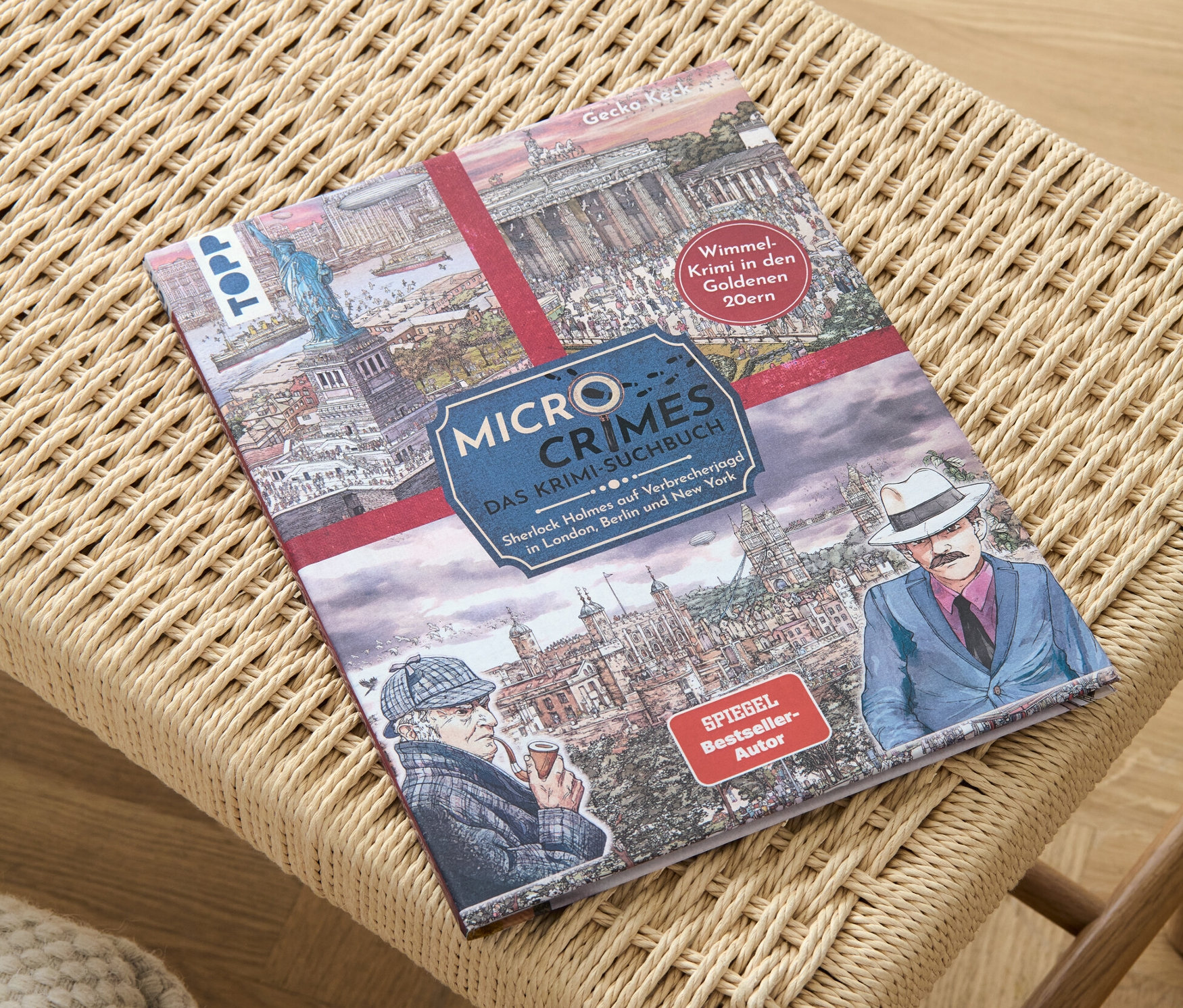 Das Buch »Micro Crimes – das Krimi-Suchbuch« liegt auf einem geflochtenen Hocker.
