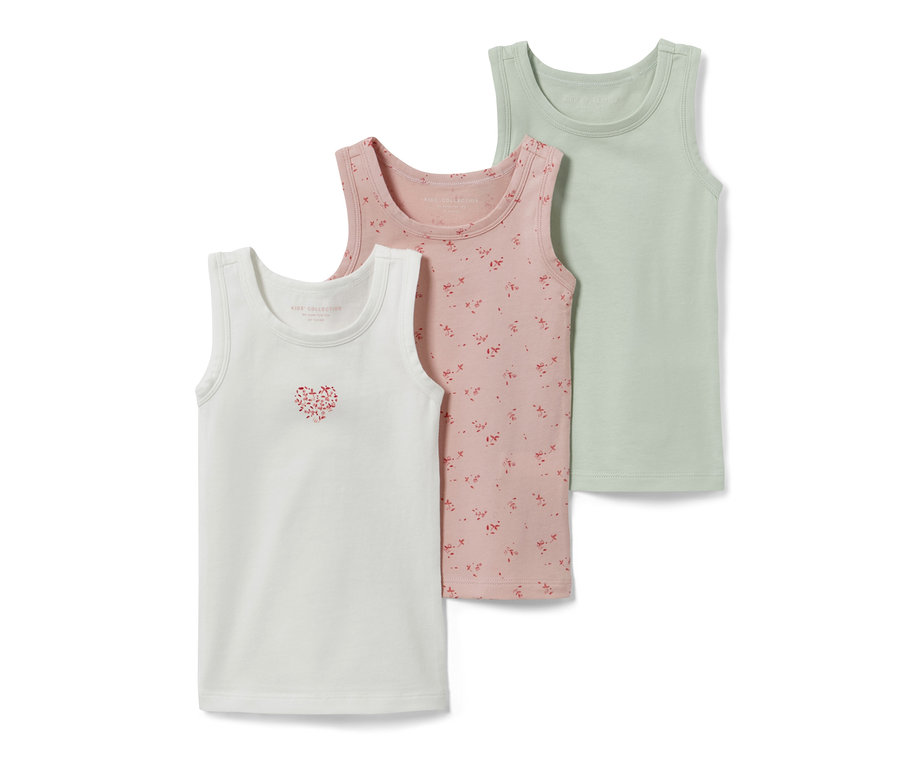 Drei Kleinkind-Unterhemden: Weiß mit Herzmotiv, rosa mit Blumenmuster und grün.