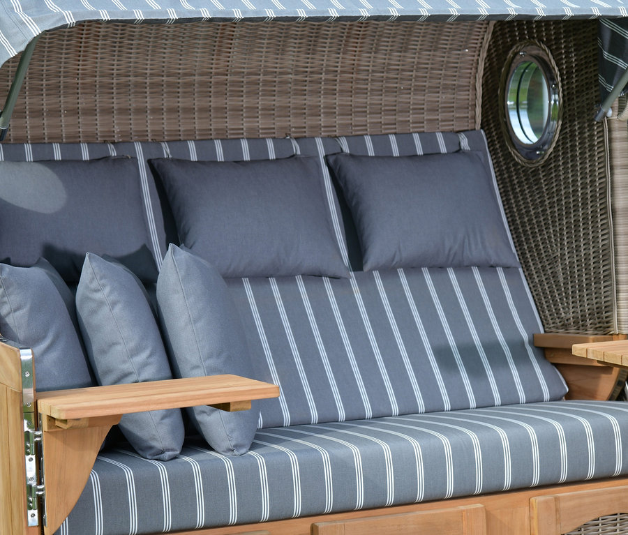 Detailansicht eines deVries Teak-Strandkorbs, 3-Sitzer, mit grauen Kissen und gestreiftem Stoff.