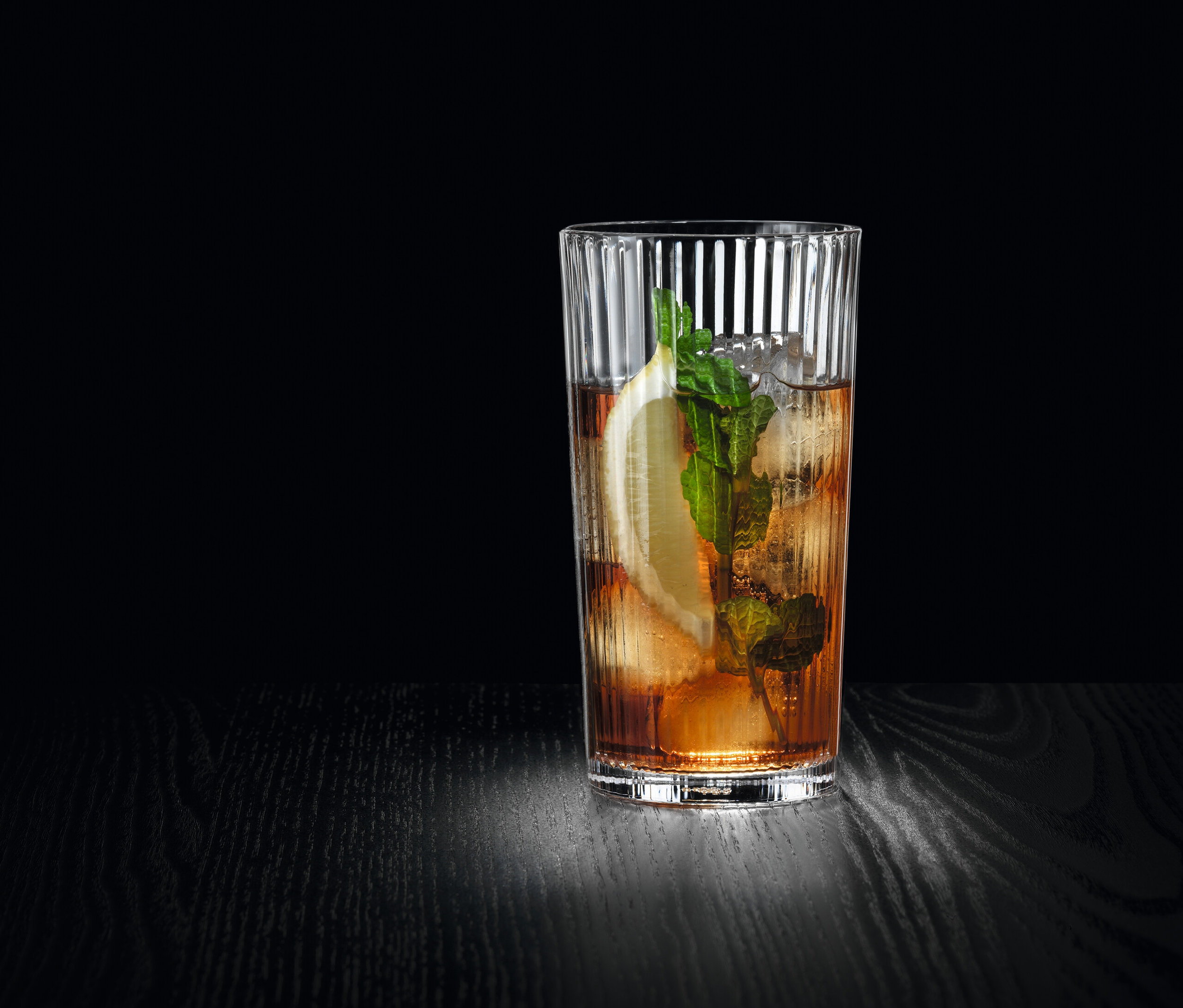 Ein Drink mit Eis, Zitrone und Minze in einem Nachtmann Aperitivo-Longdrink Glas.