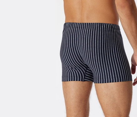 Mann von hinten trägt dunkelblaue SCHIESSER Shorts mit Bio-Baumwolle mit weißen Streifen.