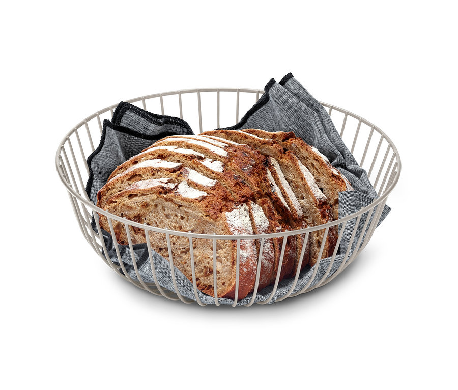 Brot liegt in einer Drahtschale mit grauem Tuch.