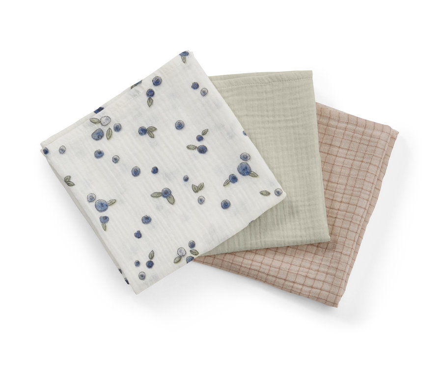Drei Baby-Musselin-Tücher: eines weiß mit Blaubeer-Muster, eines hellgrün und eines beige mit Gittermuster.