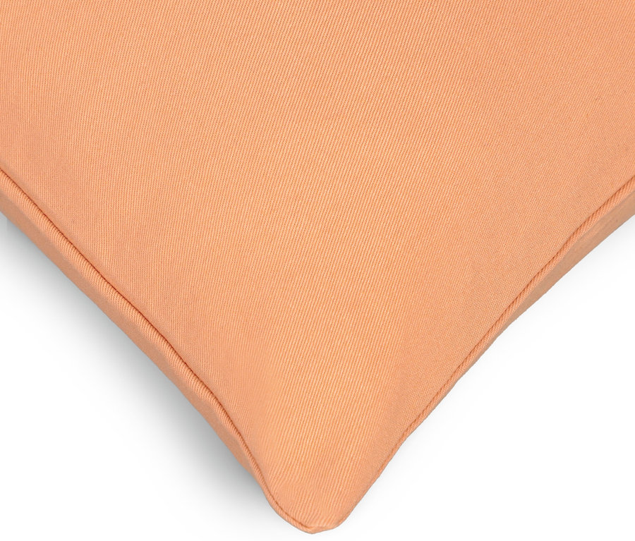 Detail einer Ecke eines pfirsichfarbenen Kissenbezugs der Marke SCHÖNER WOHNEN, ca. 50 x 50 cm.