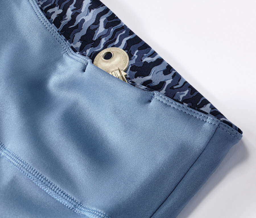 Detailansicht einer blau/hellblauen Wende-Sporttight mit einem Schlüssel in der Tasche.
