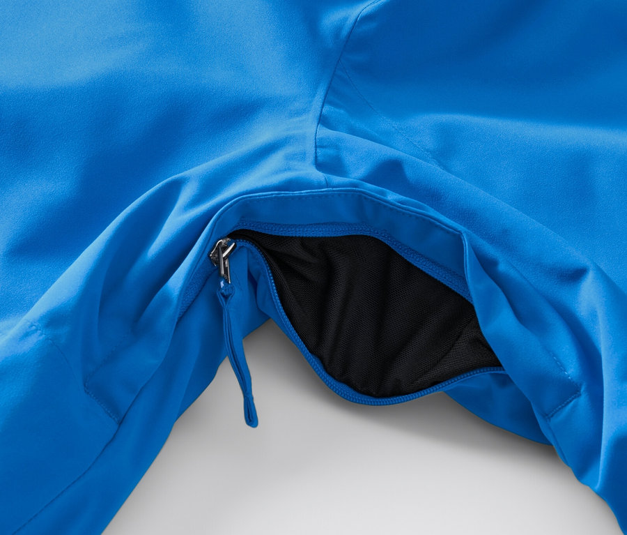 Detailansicht einer blauen High-Tech-Skijacke mit geöffneter Tasche.