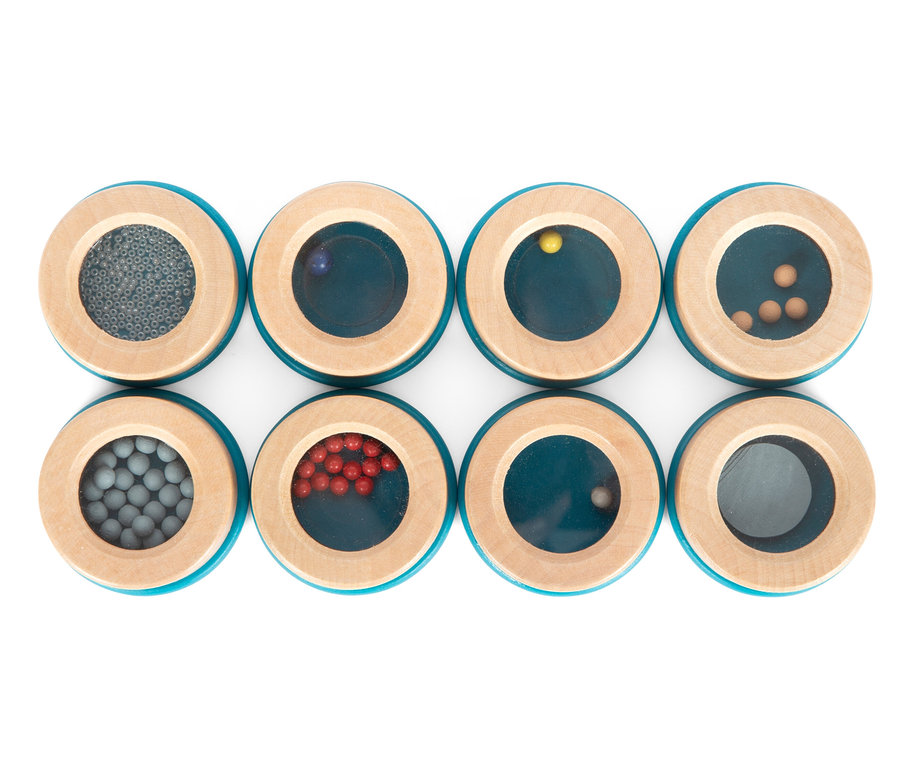 Acht hölzerne sensorische Pucks small foot Hör- und Fühl-Memo »Sensory« mit verschiedenen Materialien im Inneren.