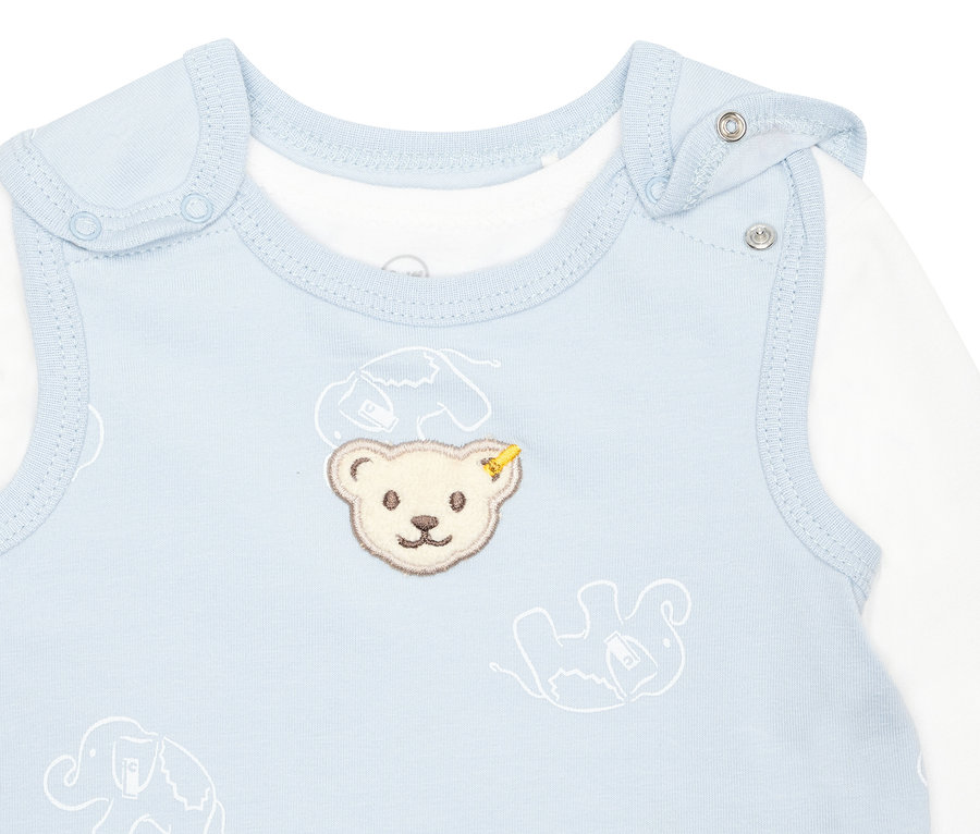 Detailansicht eines hellblauen Steiff Baby-Stramplers mit Teddybär-Stickerei und weißen Elefanten.