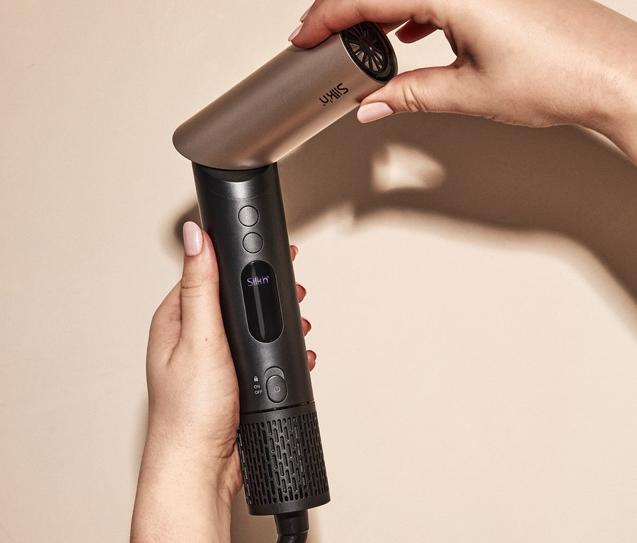 Eine Frau hält einen schwarzen Silk'n Multihaarstyler »SilkyAirFlex« in der Hand.